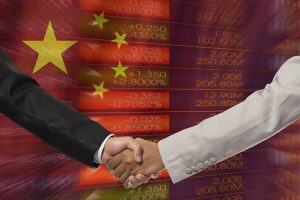 businessmen handshake after good deal in front of china flag