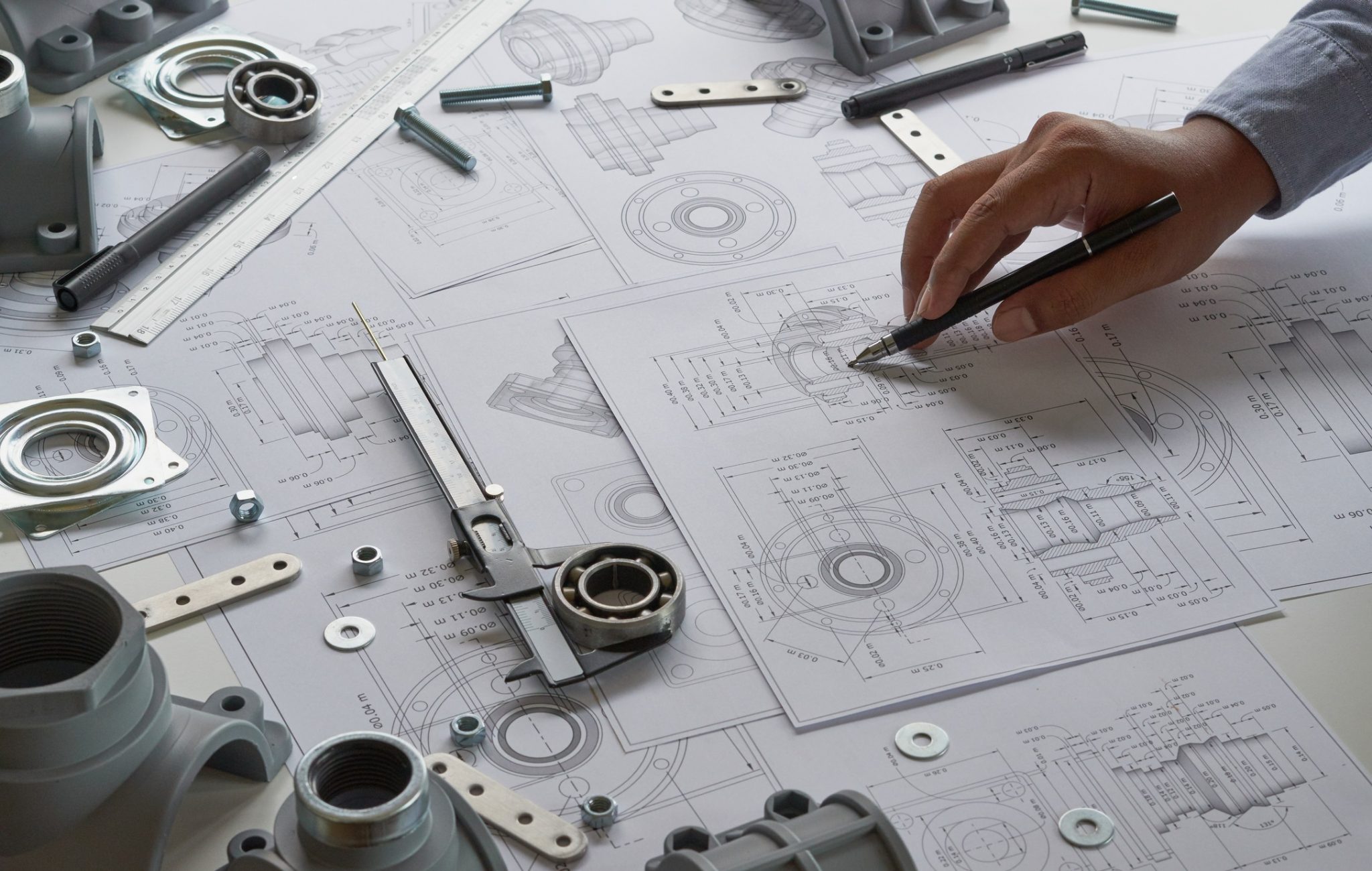 Engineer technician designing drawings mechanical parts engineering Engine
manufacturing factory Industry Industrial work project blueprints measuring bearings caliper tools